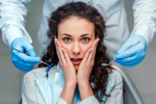 A woman suffering from dental trauma in a dental chair